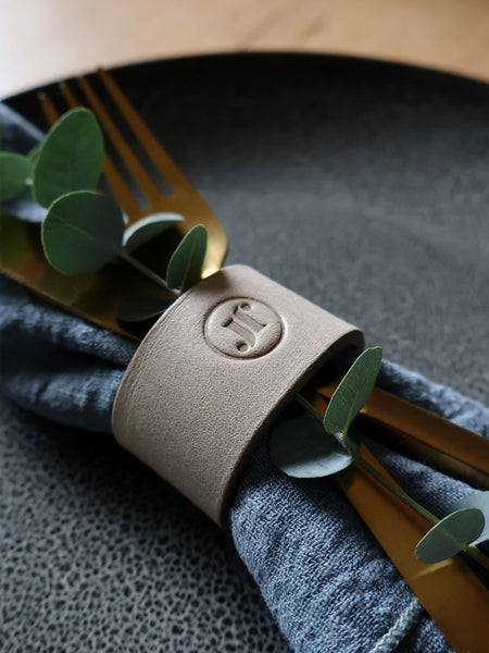 Serviettenringe handgenaeht aus Leder Farbe Stein mit Logo